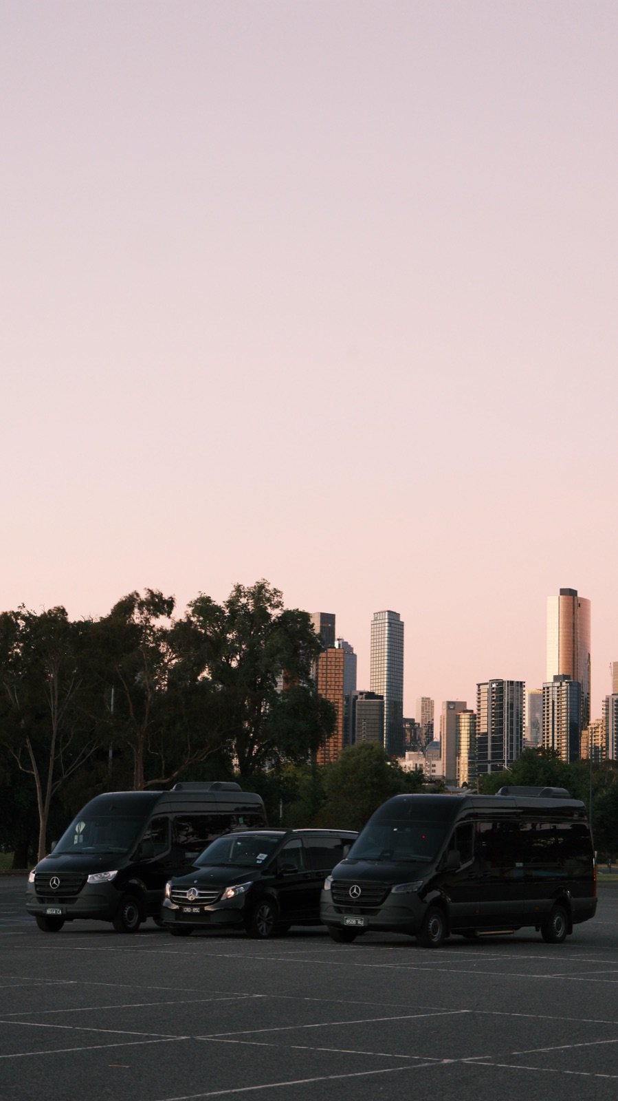 TransfersX fleet against Melbourne skyline at sunset
