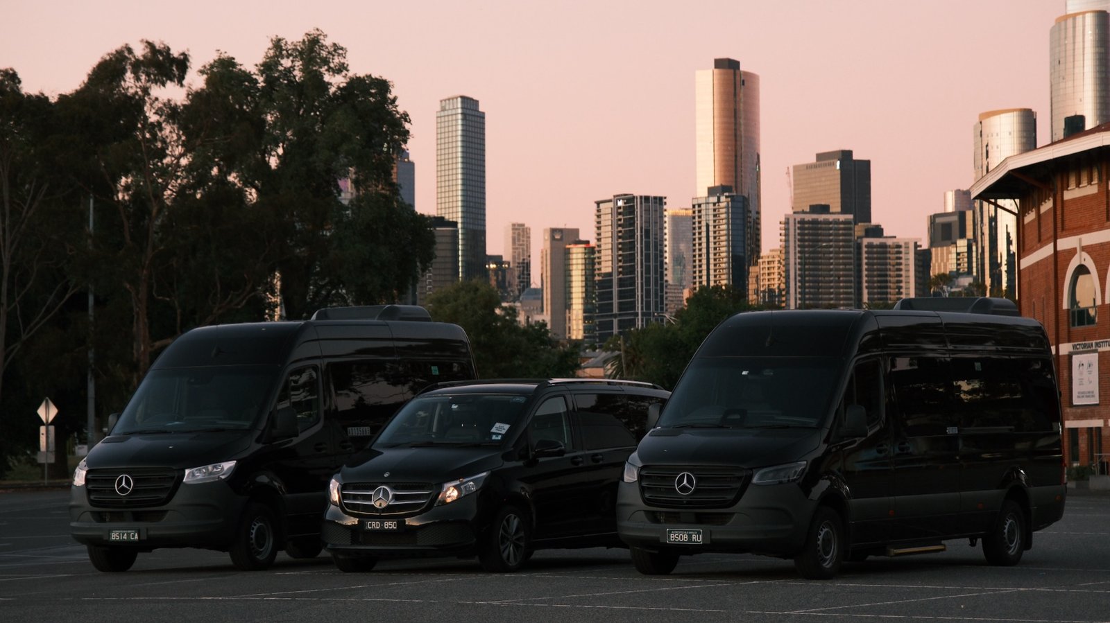 TransfersX chauffeur vehicles with the Melbourne skyline at dusk