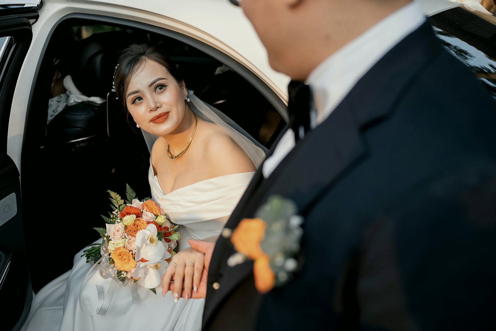 Bride stepping from the wedding car with her bouquet